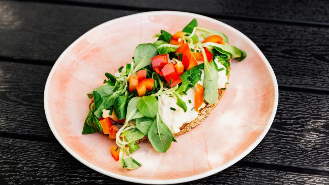 Delicious open-faced sandwich with fresh vegetables on whole grain bread, perfect for a healthy meal.